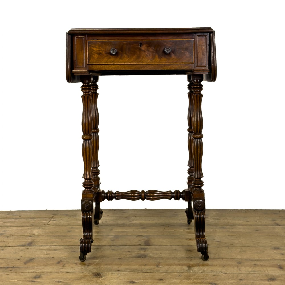 An antique Victorian dark mahogany drop-leaf work table featuring a single drawer with turned wooden knobs, fluted legs, and scroll feet on brass castors. View IX