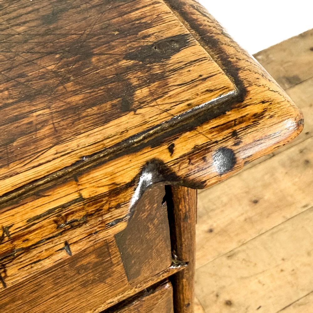 An antique 18th-century oak chest of drawers featuring a two short over three long drawer arrangement, brass handles, and turned bun feet. View VII