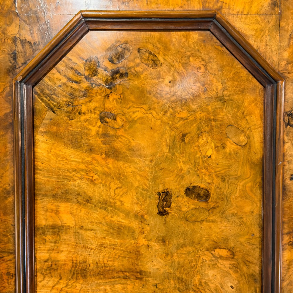 A Victorian burr walnut triple compactum wardrobe with an arched central mirrored door flanked by two panelled timber doors and topped with a castellated cornice. View XV