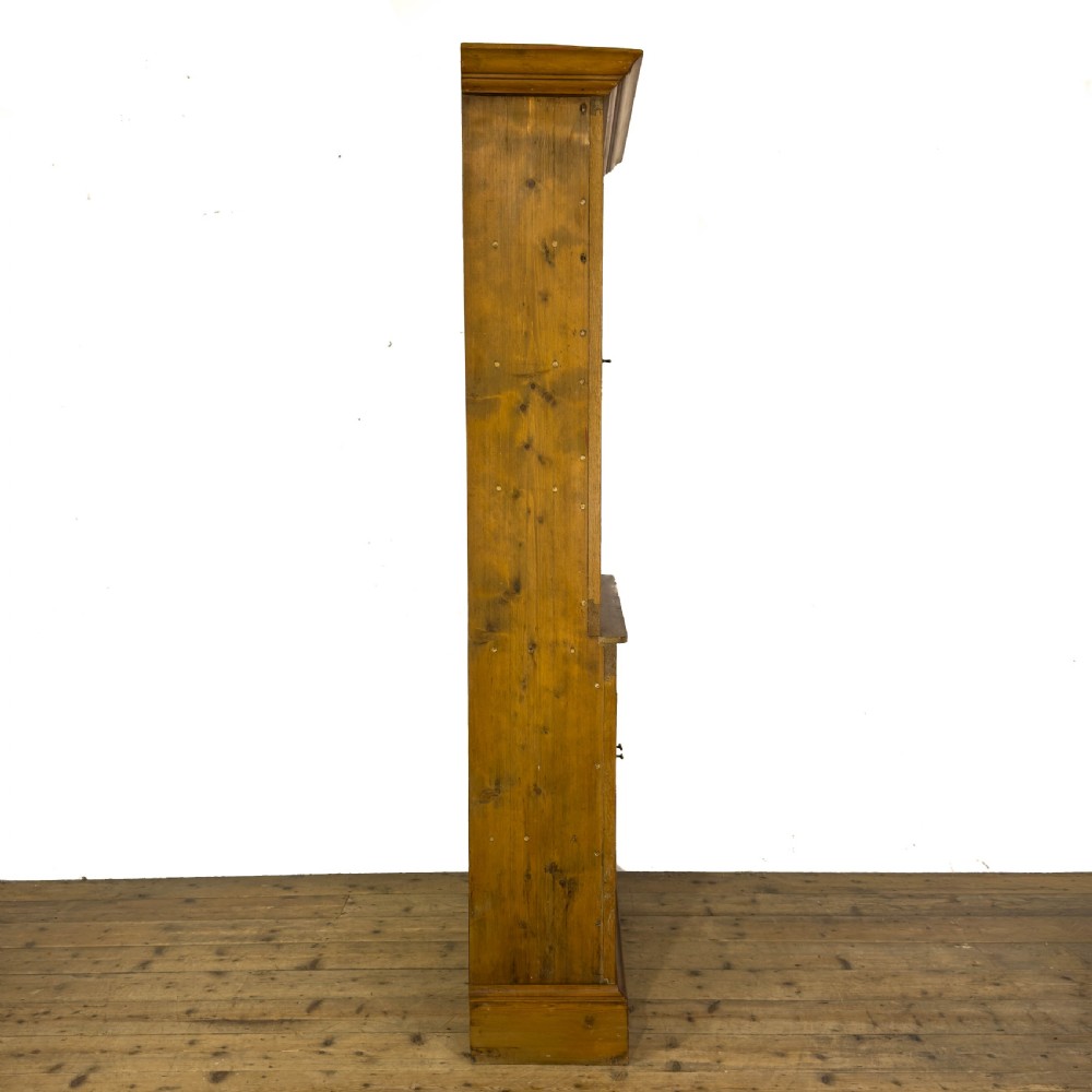An early 20th-century golden oak cupboard featuring upper glazed double doors over lower solid panelled doors with brass hardware. View IV