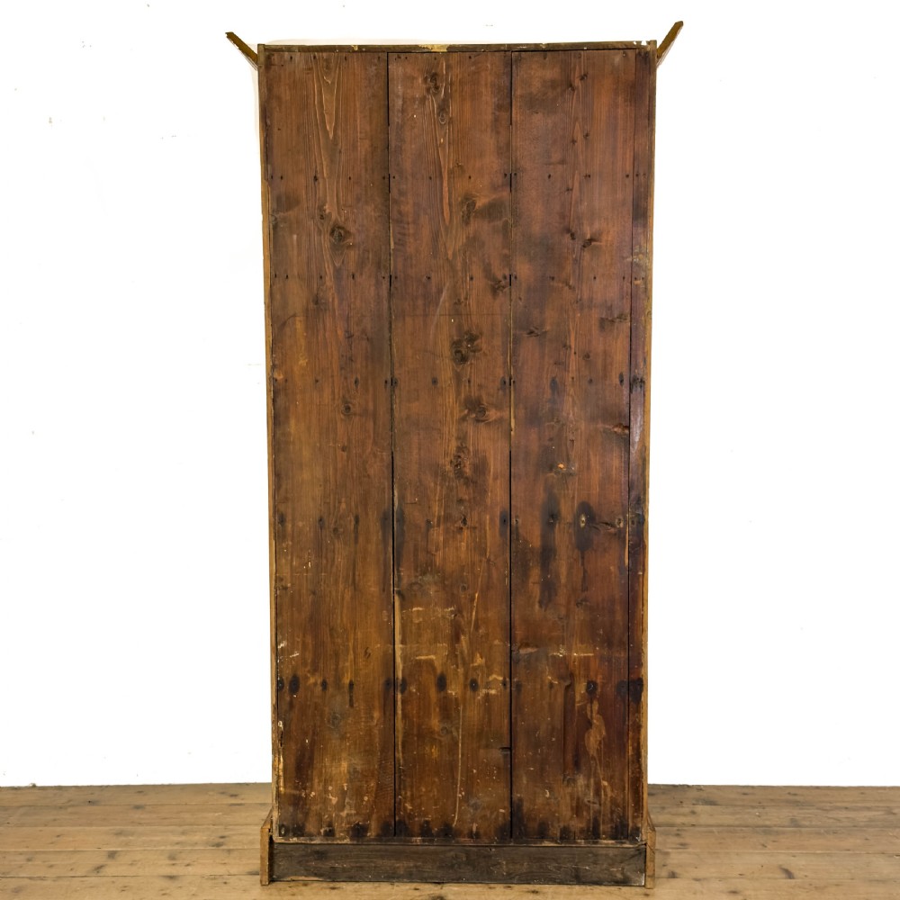 An early 20th-century golden oak cupboard featuring upper glazed double doors over lower solid panelled doors with brass hardware. View VII