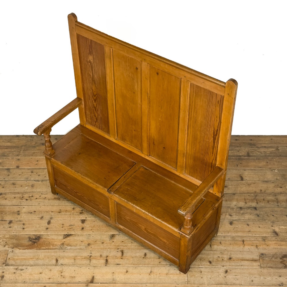 A high-backed antique pine settle bench with a four-panel backrest, turned arm supports, and a hinged seat box. View VIII