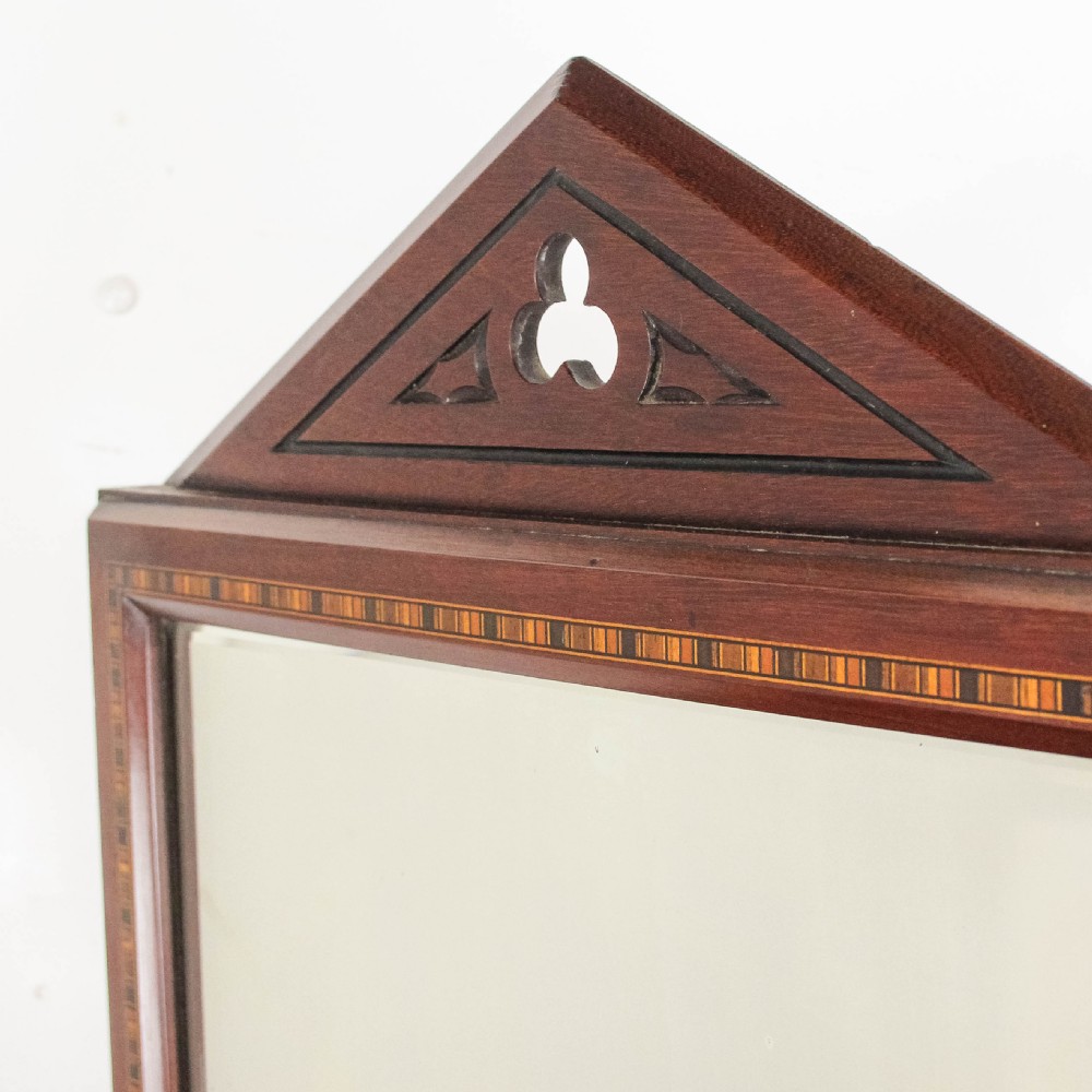 A Victorian Gothic mahogany swing mirror featuring a pointed arch pediment with a trefoil cutout, turned side columns, and geometric inlay borders. View V