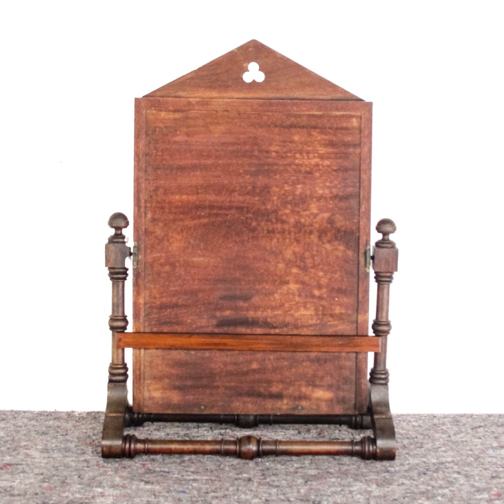 A Victorian Gothic mahogany swing mirror featuring a pointed arch pediment with a trefoil cutout, turned side columns, and geometric inlay borders. View VIII