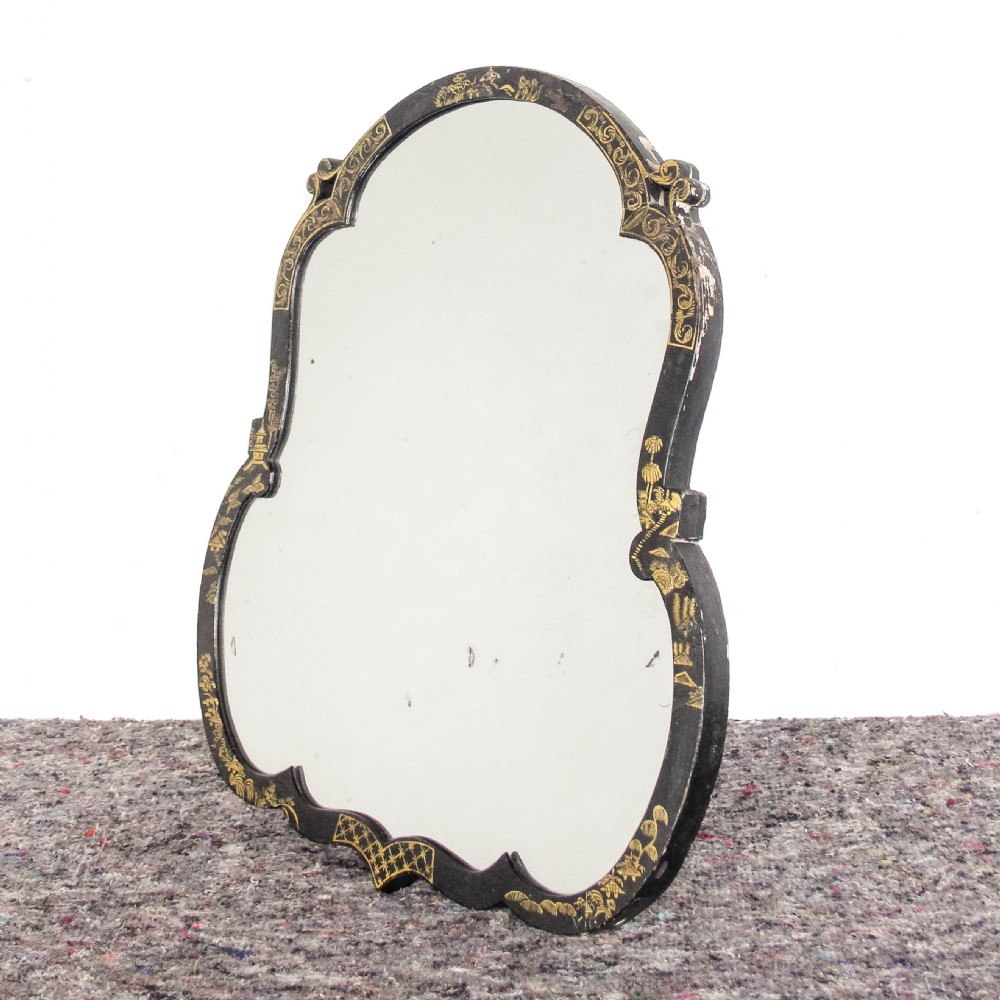An antique ebonised table mirror featuring a scalloped frame decorated with gold hand-painted chinoiserie motifs. View II