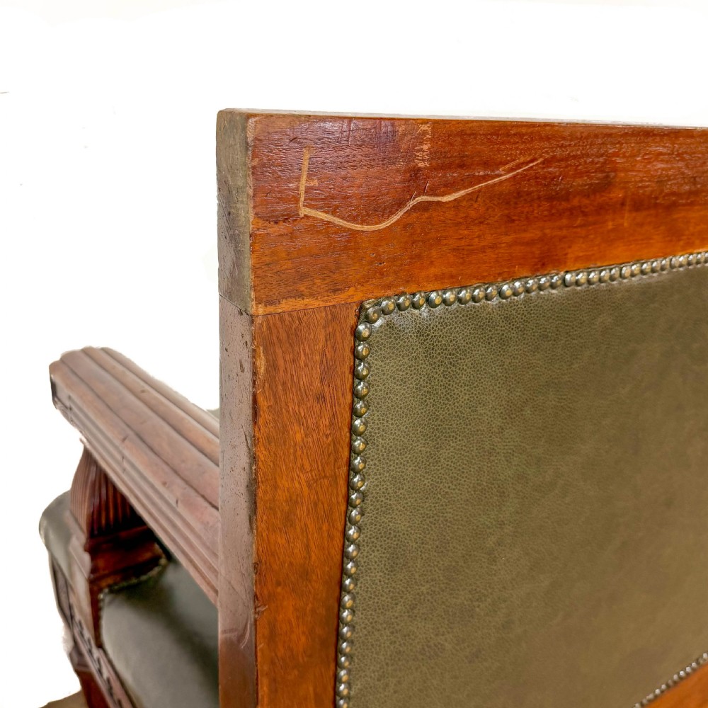 Late nineteenth-century carved oak hall settle featuring olive green leather upholstery with brass stud trim and turned legs. View V