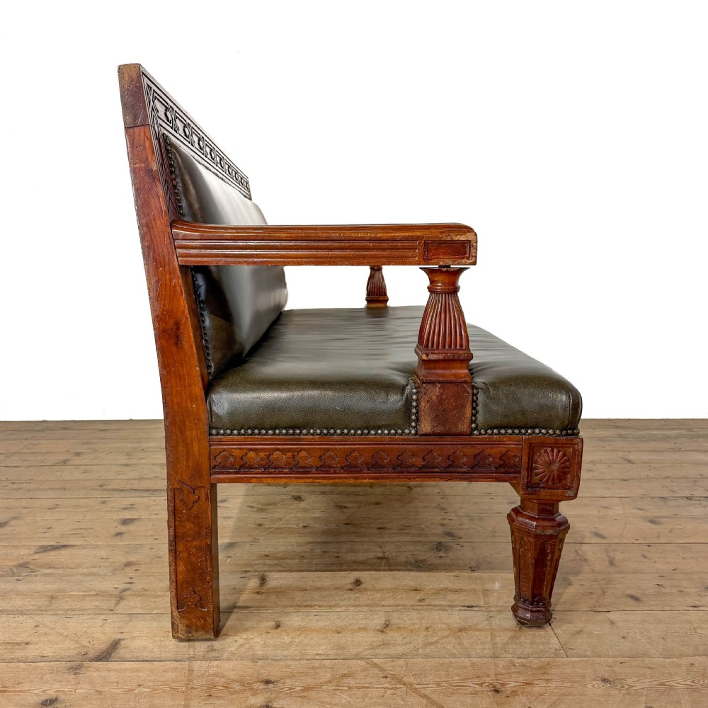 Late nineteenth-century carved oak hall settle featuring olive green leather upholstery with brass stud trim and turned legs. View IX