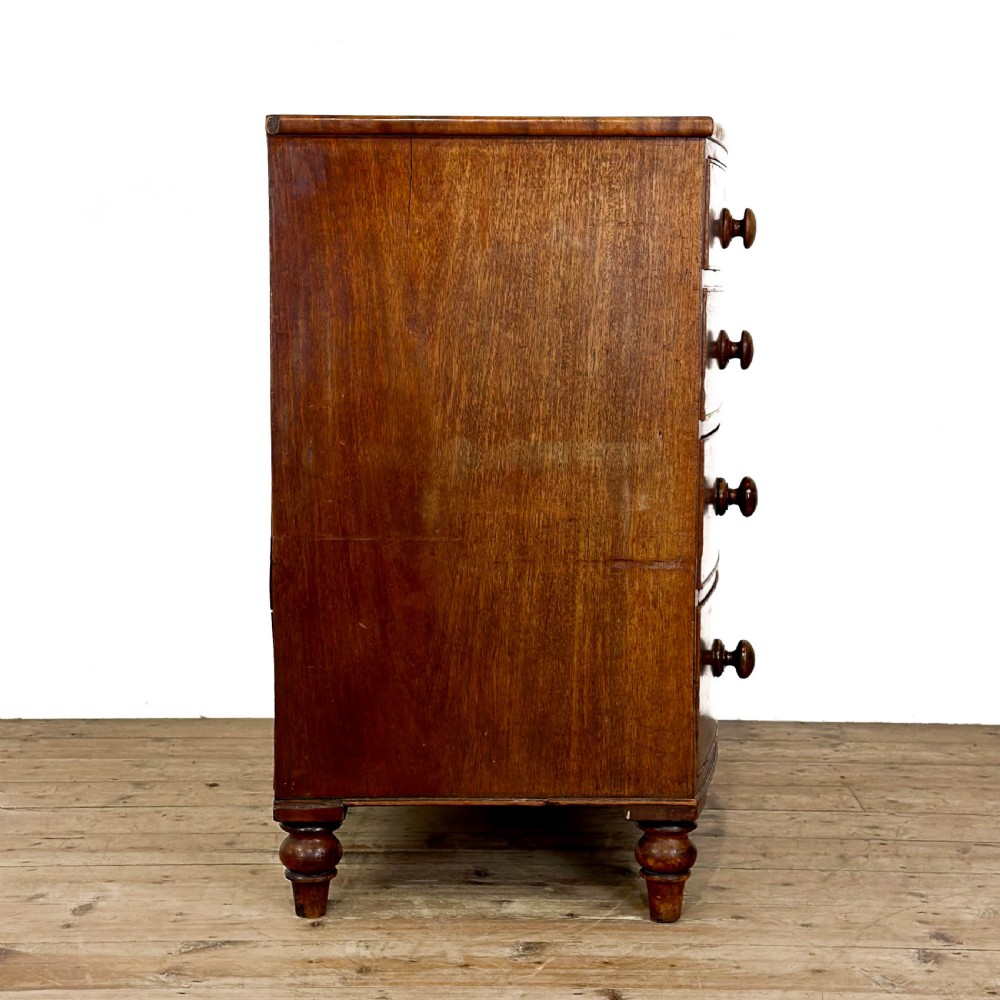 An antique mahogany bow front chest of drawers with two short drawers over three long graduated drawers, turned wooden handles, and turned feet. View VII