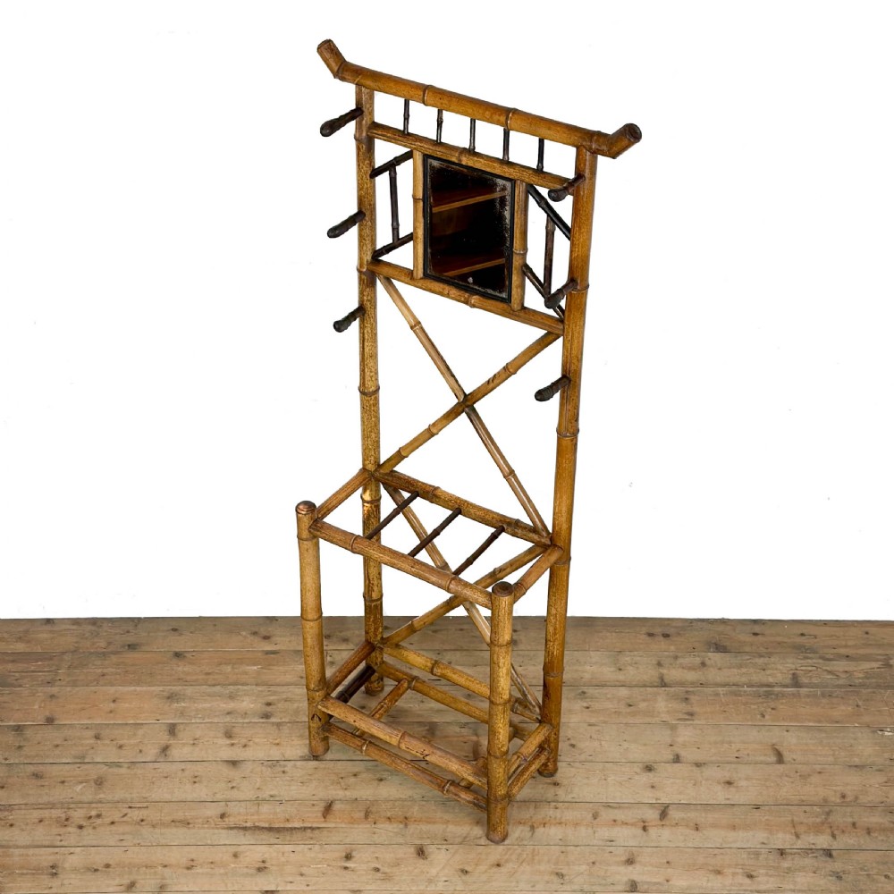 A tall Victorian bamboo hall stand featuring a central rectangular mirror, multiple turned coat pegs, cross-braced framing, and an integrated stick stand base. View III