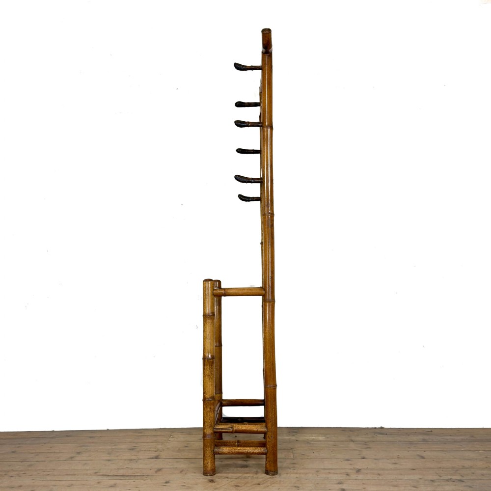 A tall Victorian bamboo hall stand featuring a central rectangular mirror, multiple turned coat pegs, cross-braced framing, and an integrated stick stand base. View IV