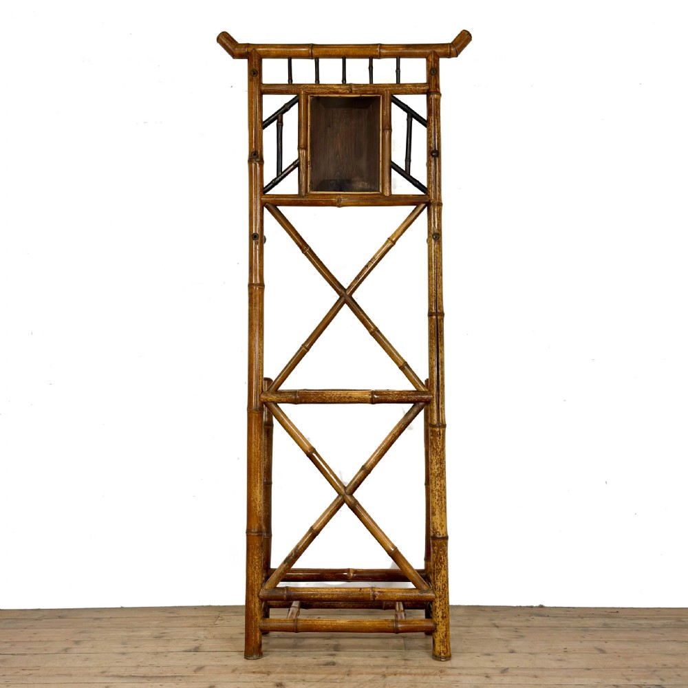 A tall Victorian bamboo hall stand featuring a central rectangular mirror, multiple turned coat pegs, cross-braced framing, and an integrated stick stand base. View V