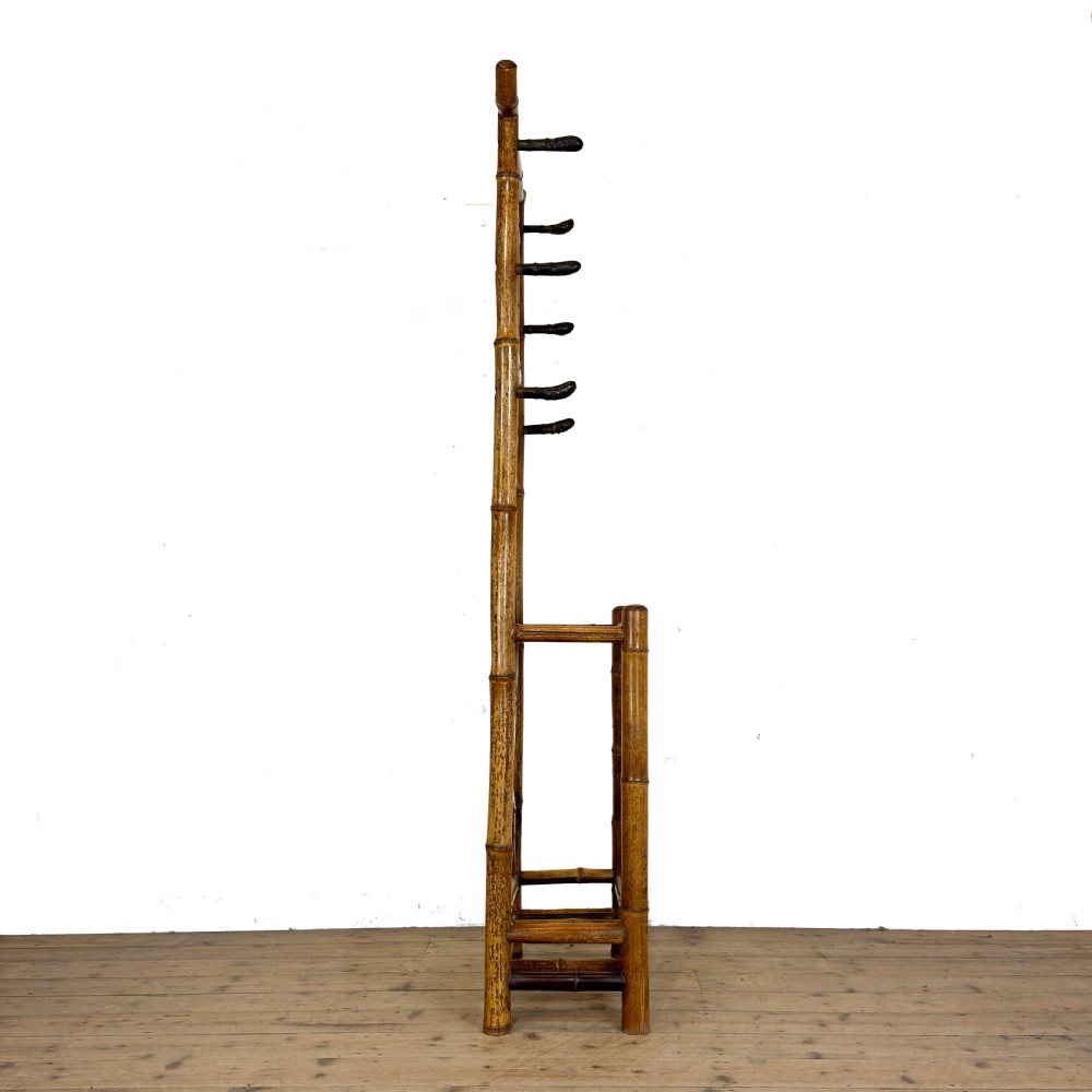 A tall Victorian bamboo hall stand featuring a central rectangular mirror, multiple turned coat pegs, cross-braced framing, and an integrated stick stand base. View VII