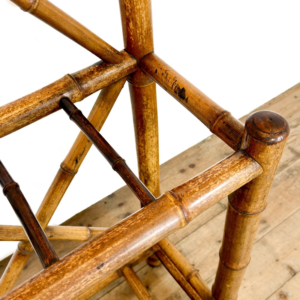 A tall Victorian bamboo hall stand featuring a central rectangular mirror, multiple turned coat pegs, cross-braced framing, and an integrated stick stand base. View VIII