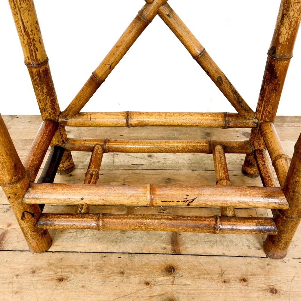 A tall Victorian bamboo hall stand featuring a central rectangular mirror, multiple turned coat pegs, cross-braced framing, and an integrated stick stand base. View IX