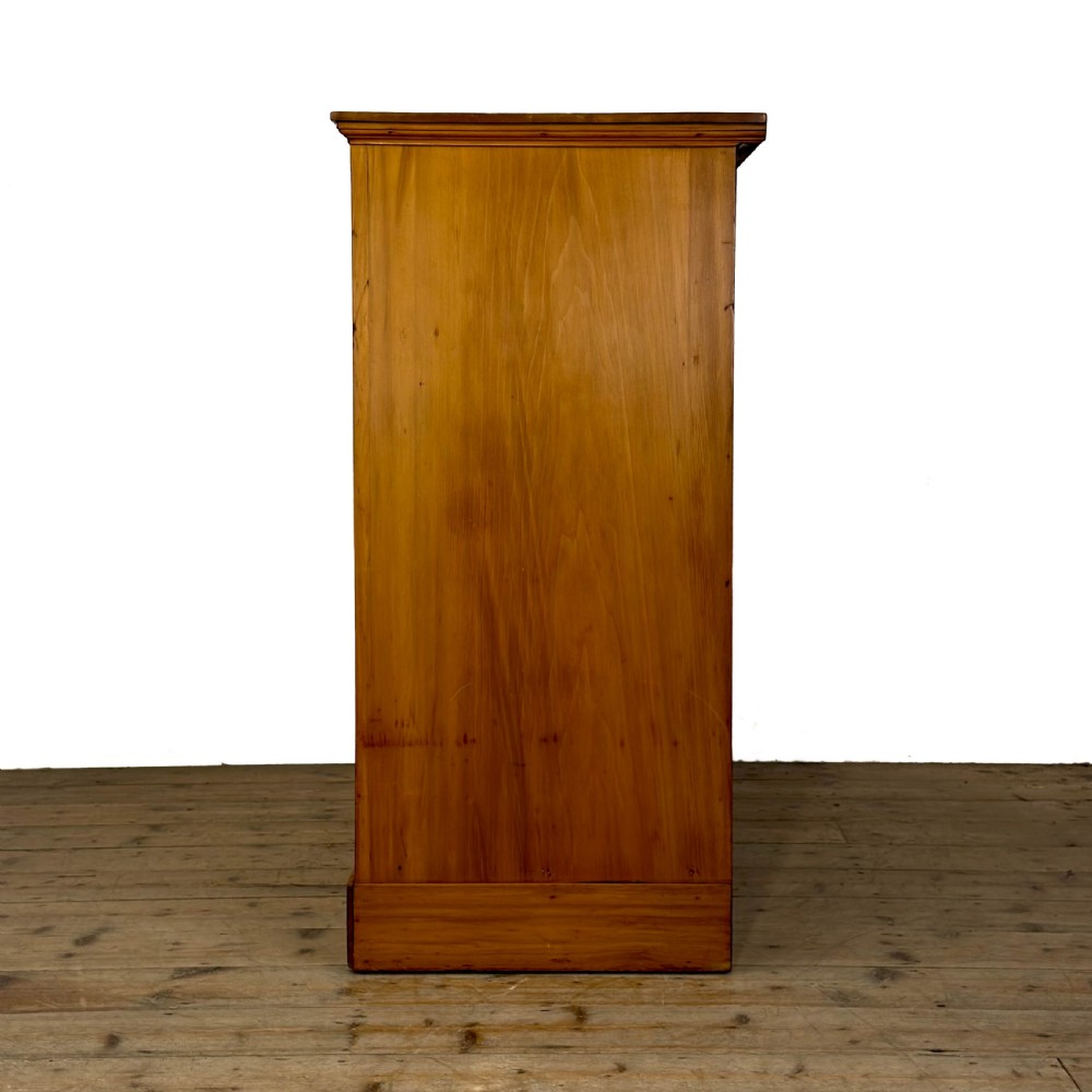 An Edwardian pine chest of drawers featuring two short drawers above three long drawers with reeded drawer fronts and brass cup handles. View VII