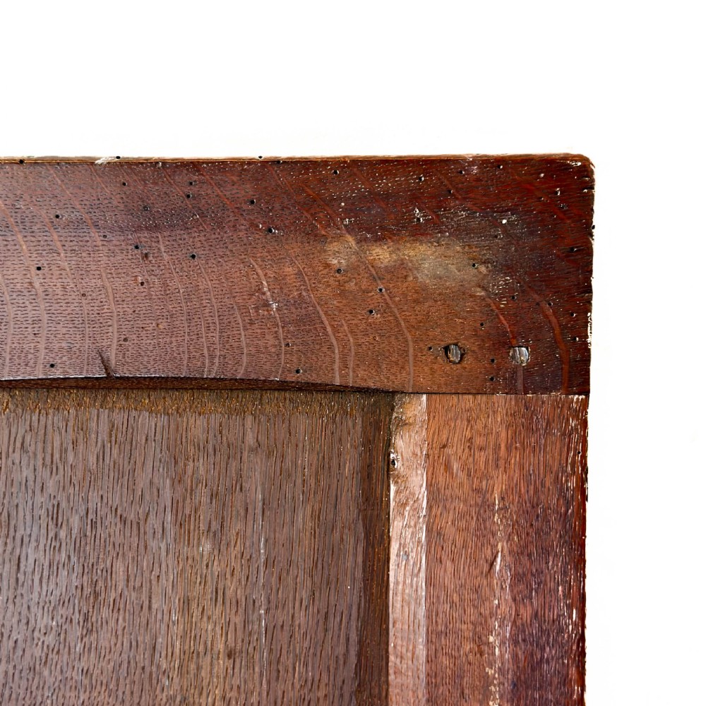 A dark oak coffer with three carved lunette frieze panels above recessed lower panels and an iron lock plate. View VII