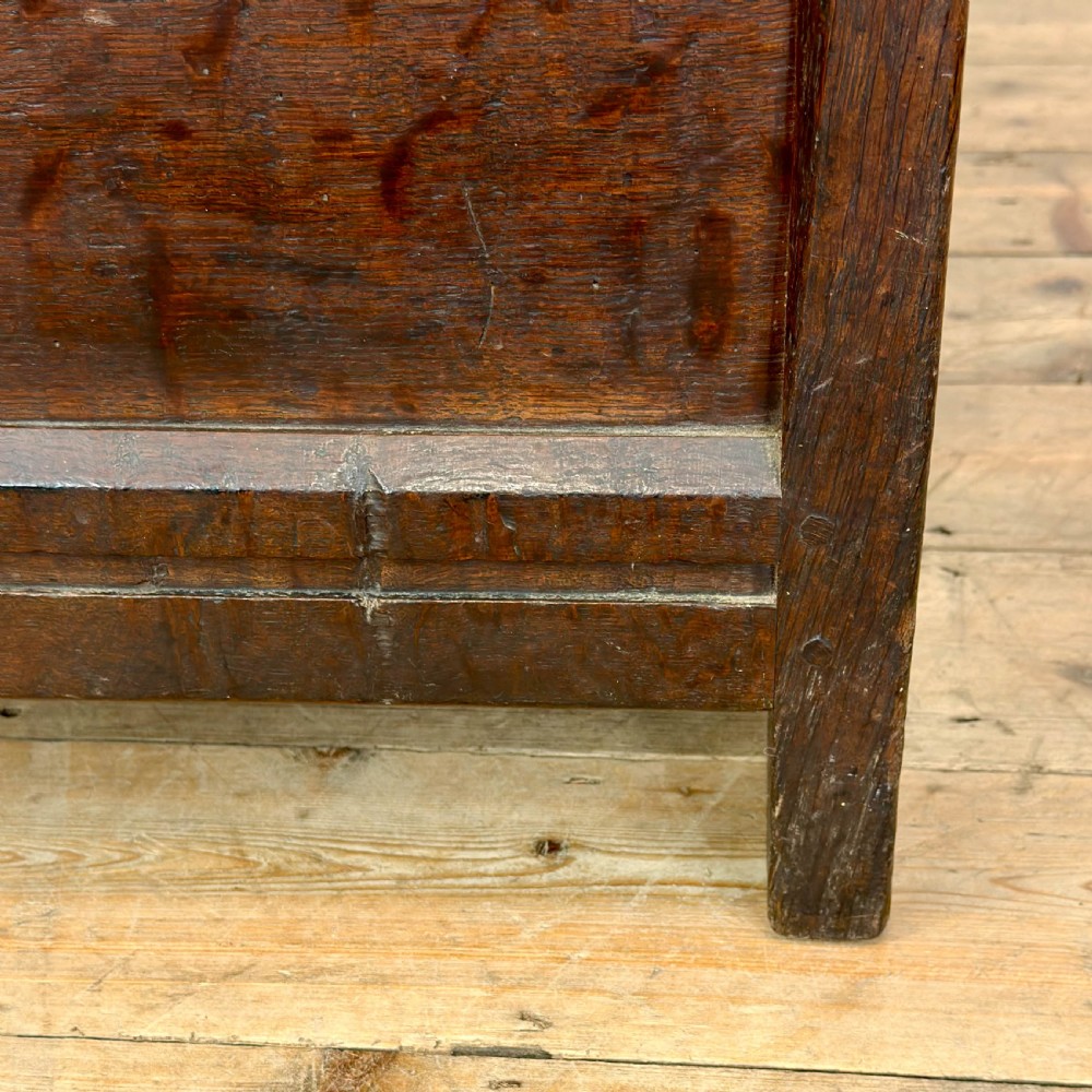 A dark oak coffer with three carved lunette frieze panels above recessed lower panels and an iron lock plate. View IX