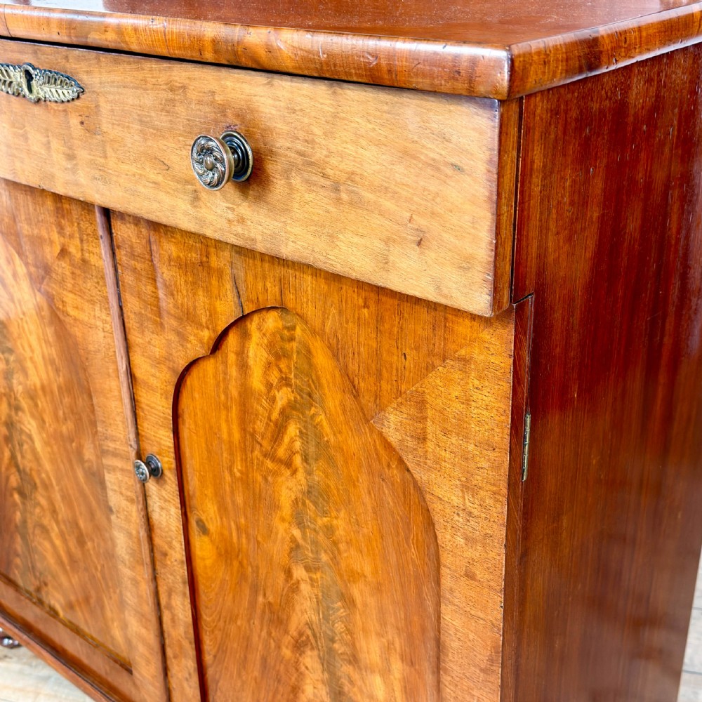 A Victorian mahogany chiffonier sideboard featuring a raised back shelf on turned supports, a frieze drawer with brass hardware, and two arched cupboard doors. View VII
