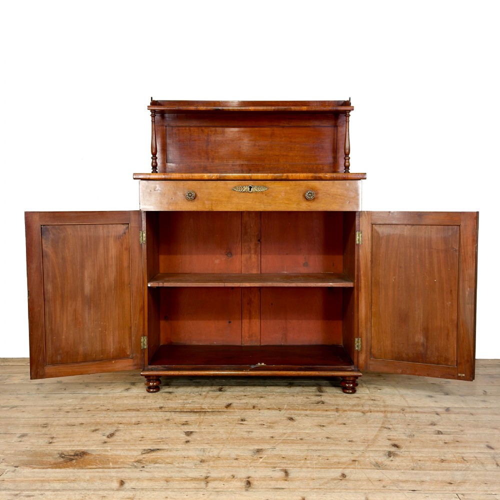 A Victorian mahogany chiffonier sideboard featuring a raised back shelf on turned supports, a frieze drawer with brass hardware, and two arched cupboard doors. View IX