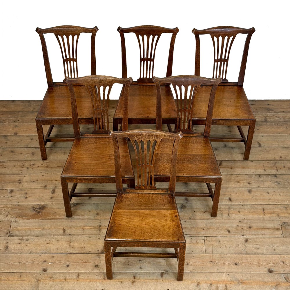 A set of six medium brown antique oak dining chairs featuring vertical splat backs, solid wooden seats, and stretcher bases. View II