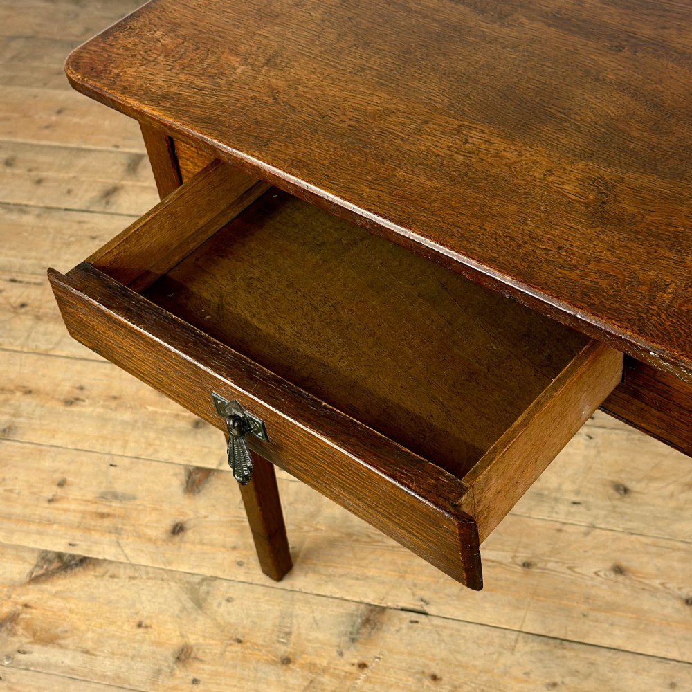 A dark oak rectangular side table featuring a single drawer with a metal drop handle and four straight legs. View VII