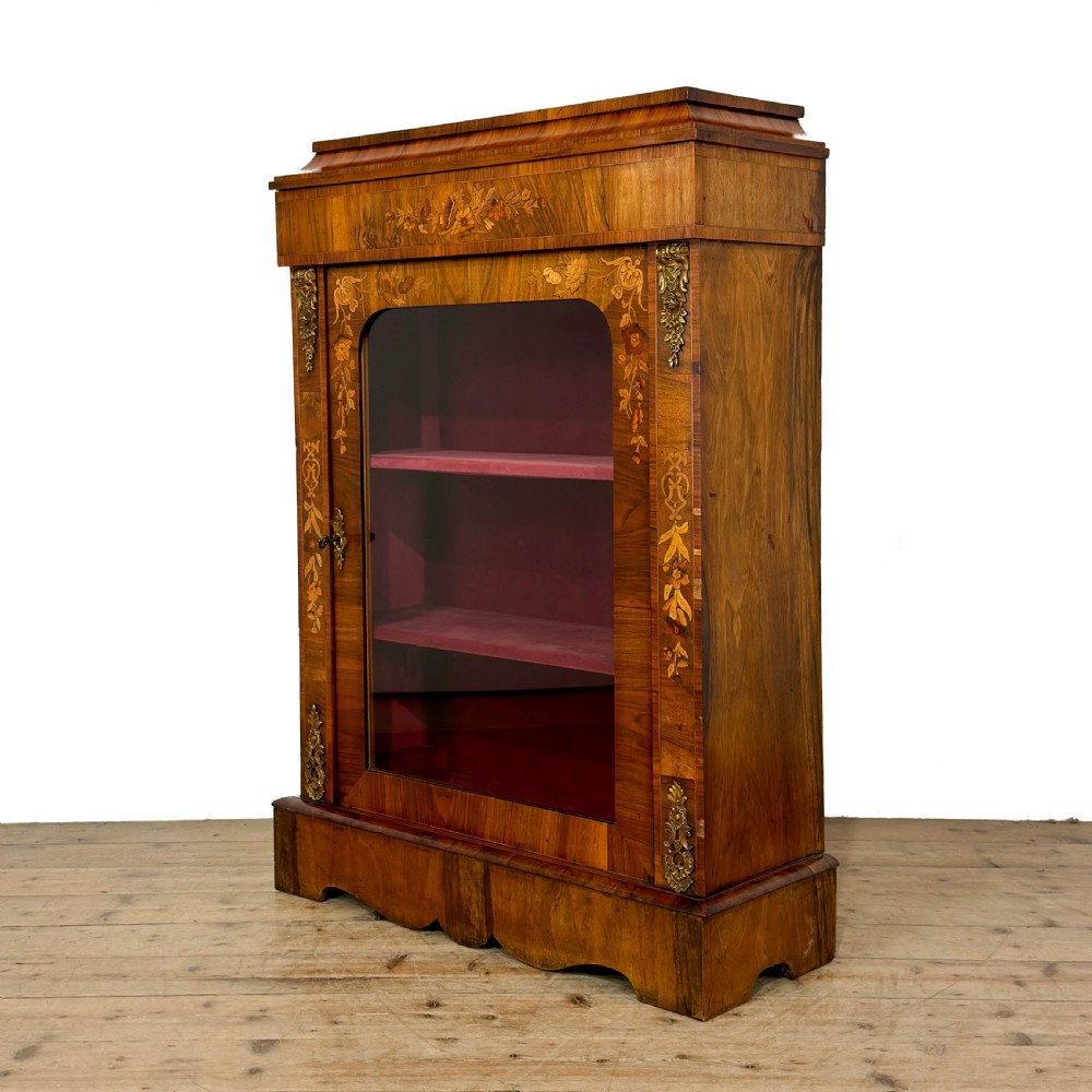 A Victorian walnut pier cabinet featuring floral marquetry inlays, gilt metal mounts, a single glazed door, and a red fabric-lined interior with two shelves. View III