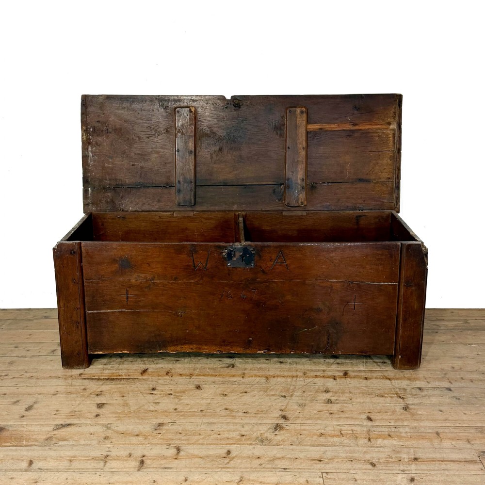 A large dark oak coffer featuring the carved initials W A, the date 1647, two small carved crosses, and a central iron lockplate. View II