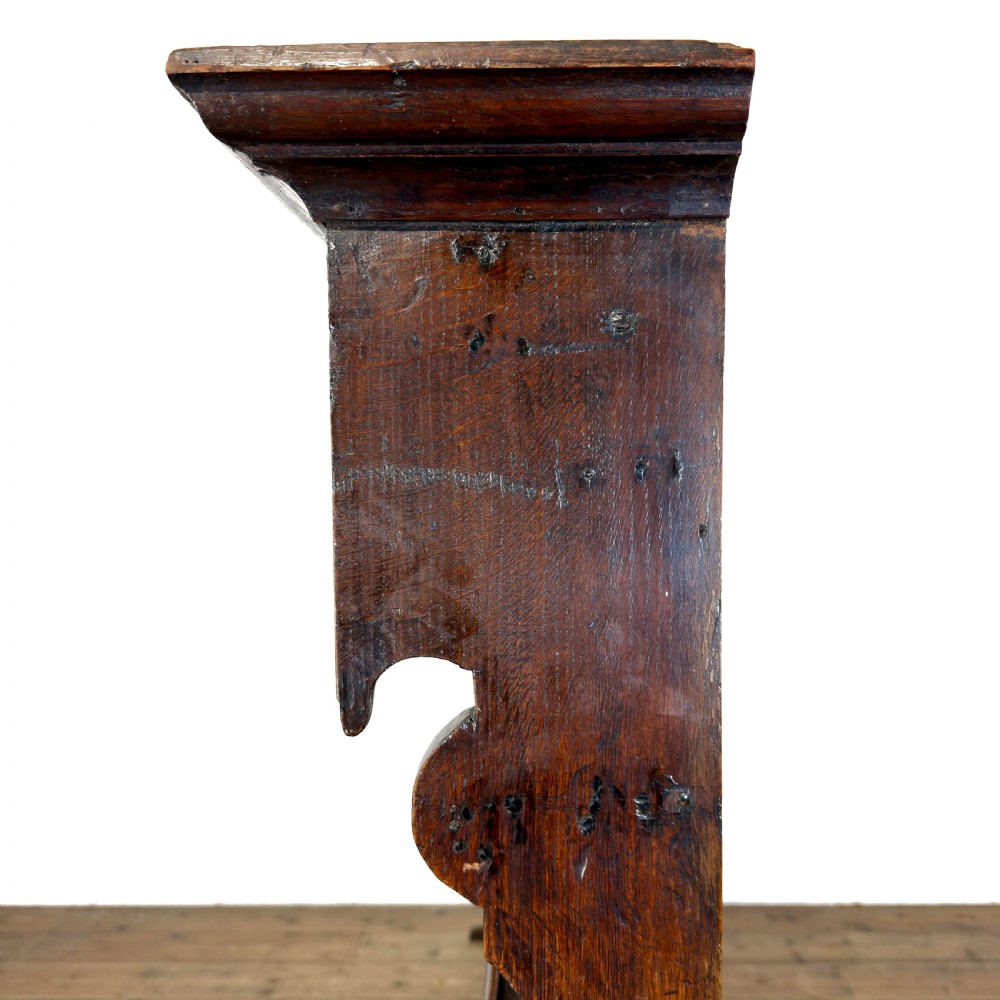 A dark oak wooden dresser rack featuring three horizontal shelves and a scalloped top frieze. View V