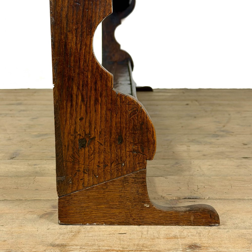 A dark oak wooden dresser rack featuring three horizontal shelves and a scalloped top frieze. View VIII