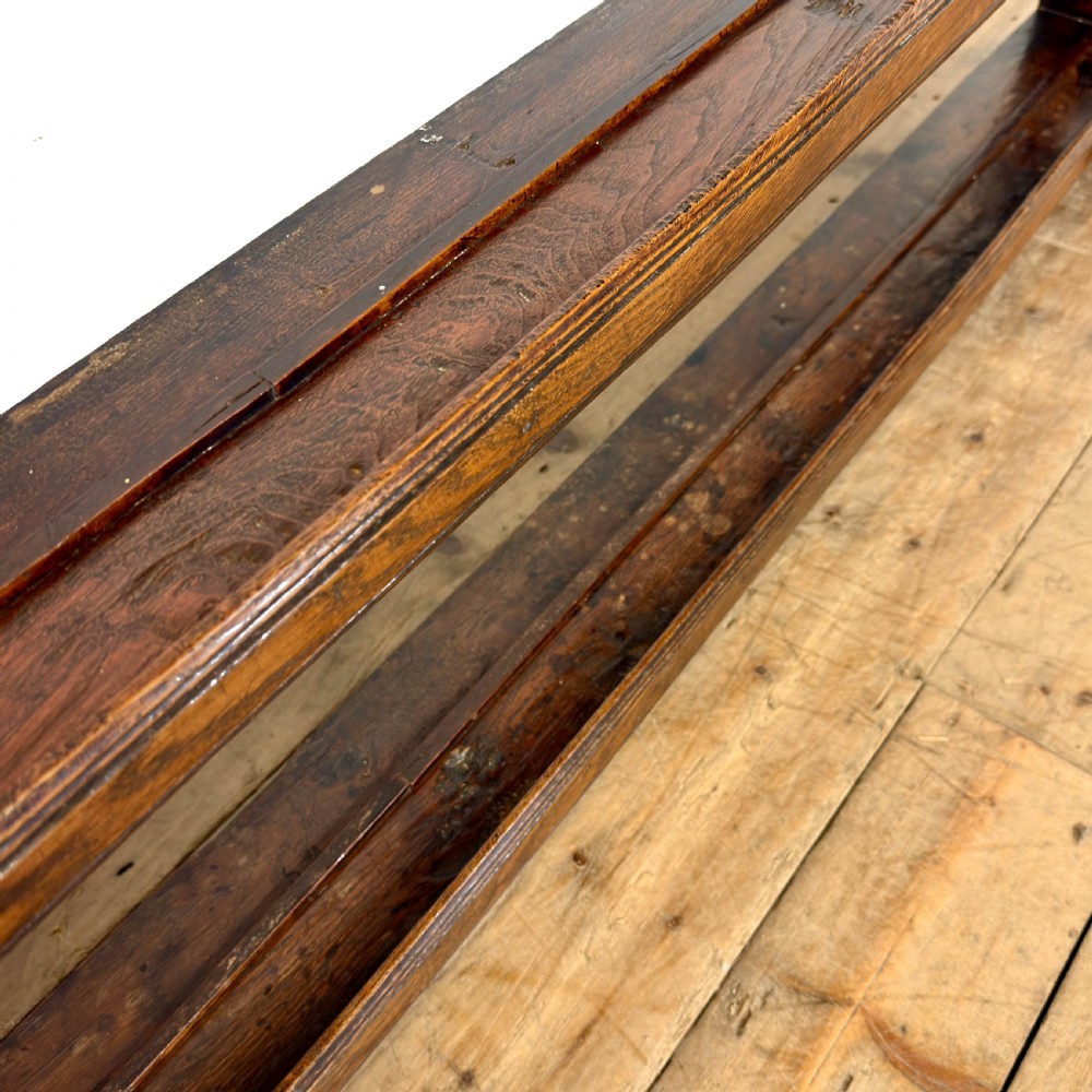 A dark oak wooden dresser rack featuring three horizontal shelves and a scalloped top frieze. View IX
