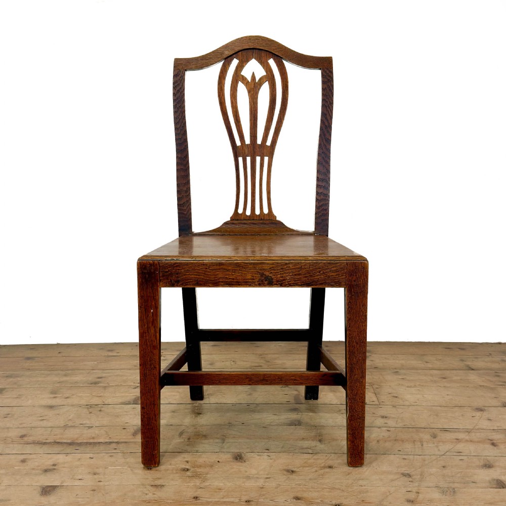 A set of six 19th-century oak dining chairs featuring pierced back splats, solid wooden seats, and straight legs connected by stretchers. View IV