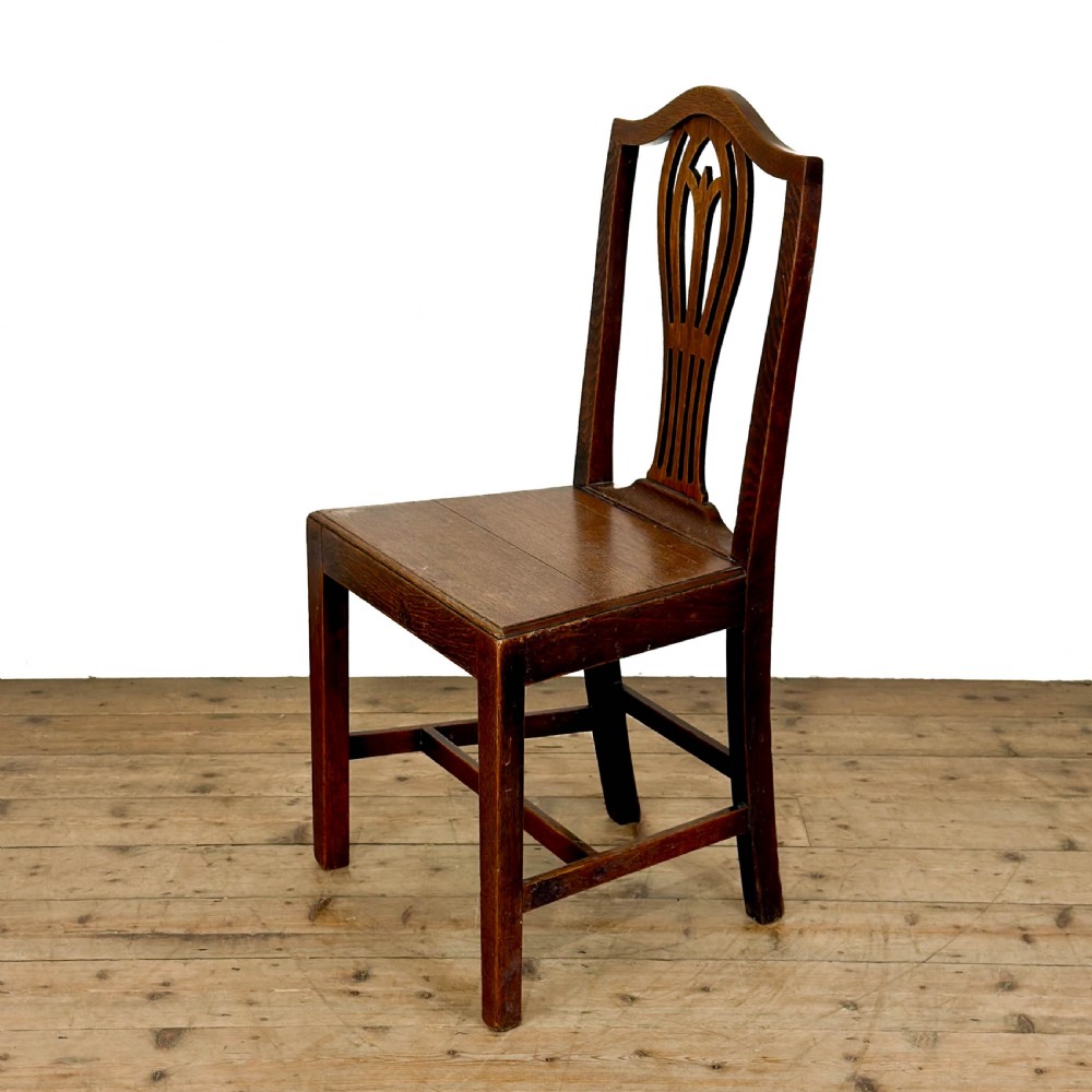 A set of six 19th-century oak dining chairs featuring pierced back splats, solid wooden seats, and straight legs connected by stretchers. View V