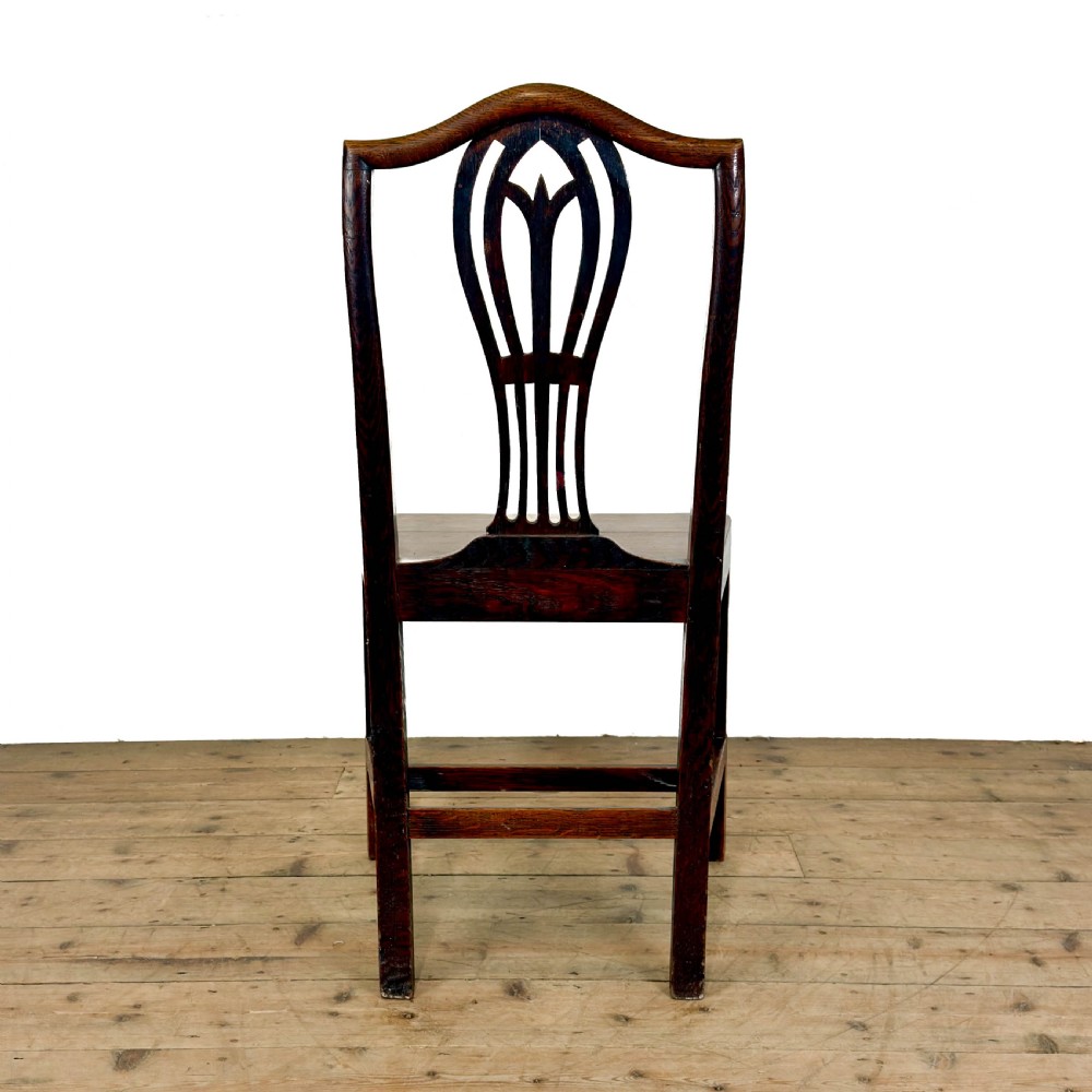 A set of six 19th-century oak dining chairs featuring pierced back splats, solid wooden seats, and straight legs connected by stretchers. View VII