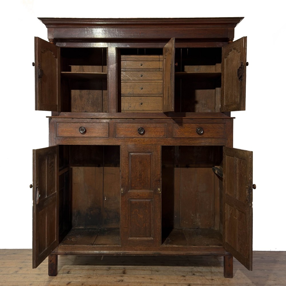 An 18th-century dark oak Welsh cwpwrdd deuddarn cupboard featuring two tiers with arched panelled doors and three lower drawers. View III