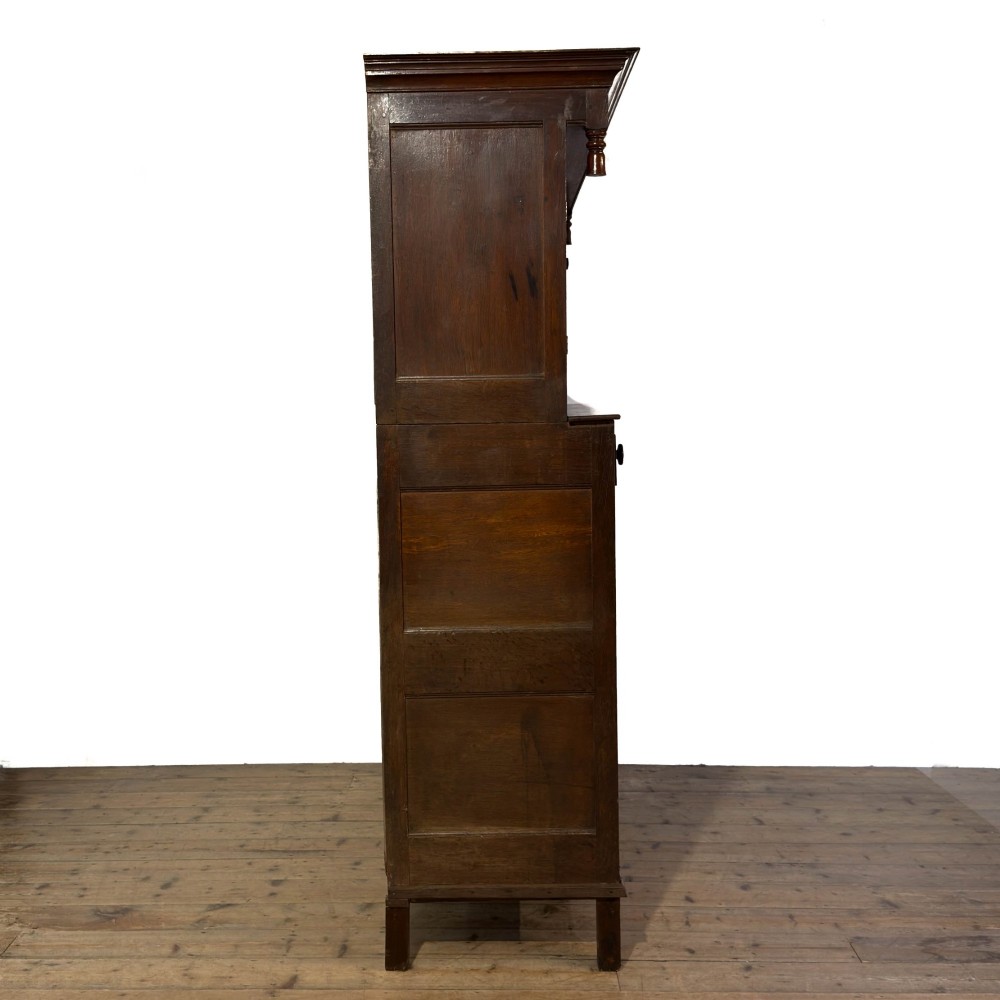 An 18th-century dark oak Welsh cwpwrdd deuddarn cupboard featuring two tiers with arched panelled doors and three lower drawers. View VII