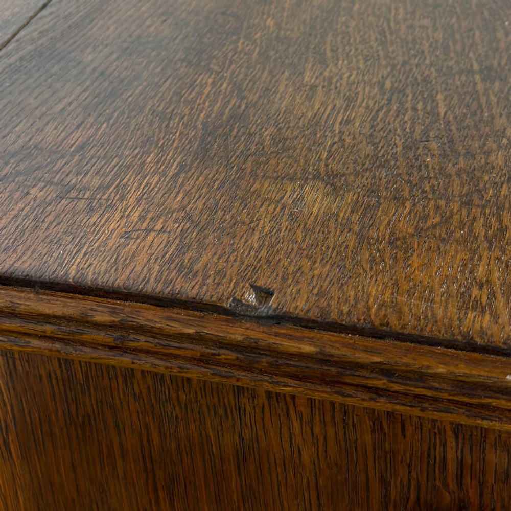 An antique Georgian oak chest of drawers featuring two short drawers over three long drawers with turned wooden knobs and a shaped apron. View V