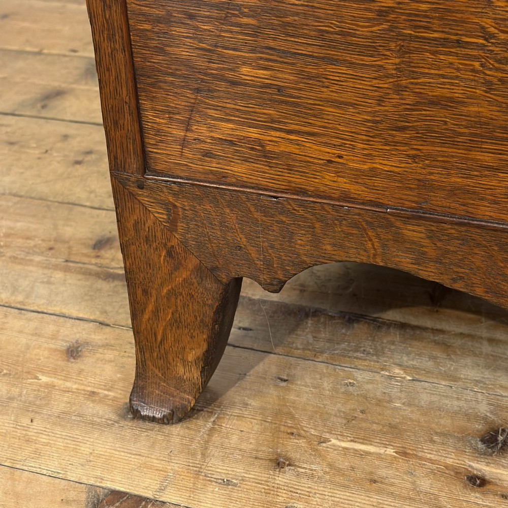 An antique Georgian oak chest of drawers featuring two short drawers over three long drawers with turned wooden knobs and a shaped apron. View VII