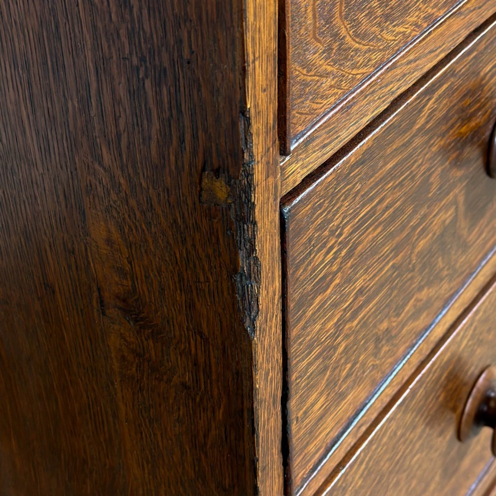 An antique Georgian oak chest of drawers featuring two short drawers over three long drawers with turned wooden knobs and a shaped apron. View IX