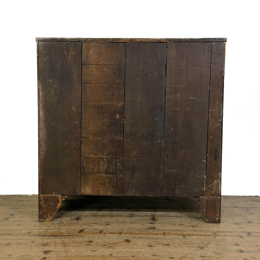 An antique Georgian oak chest of drawers featuring two short drawers over three long drawers with turned wooden knobs and a shaped apron. View X