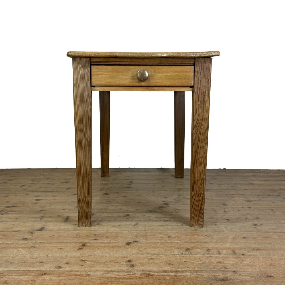 A rustic pine kitchen table featuring a single frieze drawer with a round wooden knob handle and four straight legs.