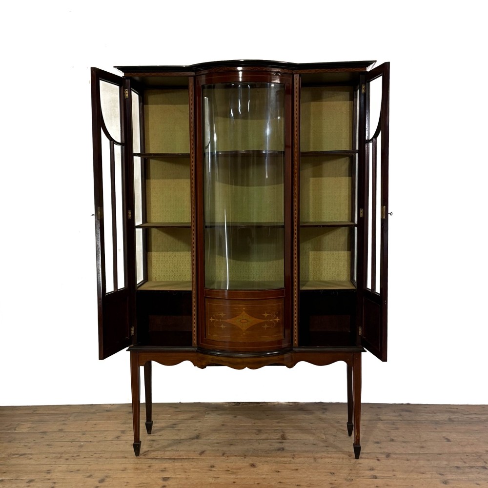 An Edwardian mahogany display cabinet featuring a central bow-front glazed door with marquetry inlay flanked by two side glazed panels. View II