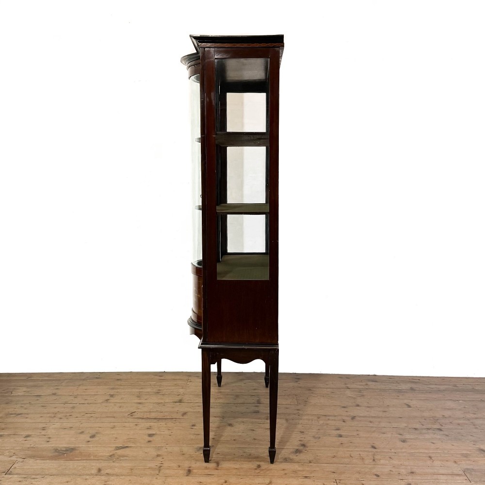 An Edwardian mahogany display cabinet featuring a central bow-front glazed door with marquetry inlay flanked by two side glazed panels. View V