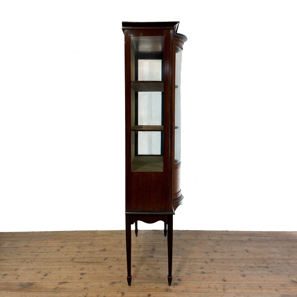 An Edwardian mahogany display cabinet featuring a central bow-front glazed door with marquetry inlay flanked by two side glazed panels. View VII