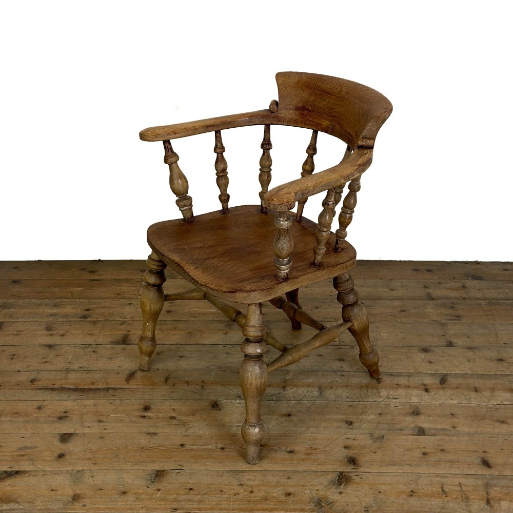 An antique wooden smokers bow armchair with turned spindles, a curved horseshoe armrest, and turned legs. View VII