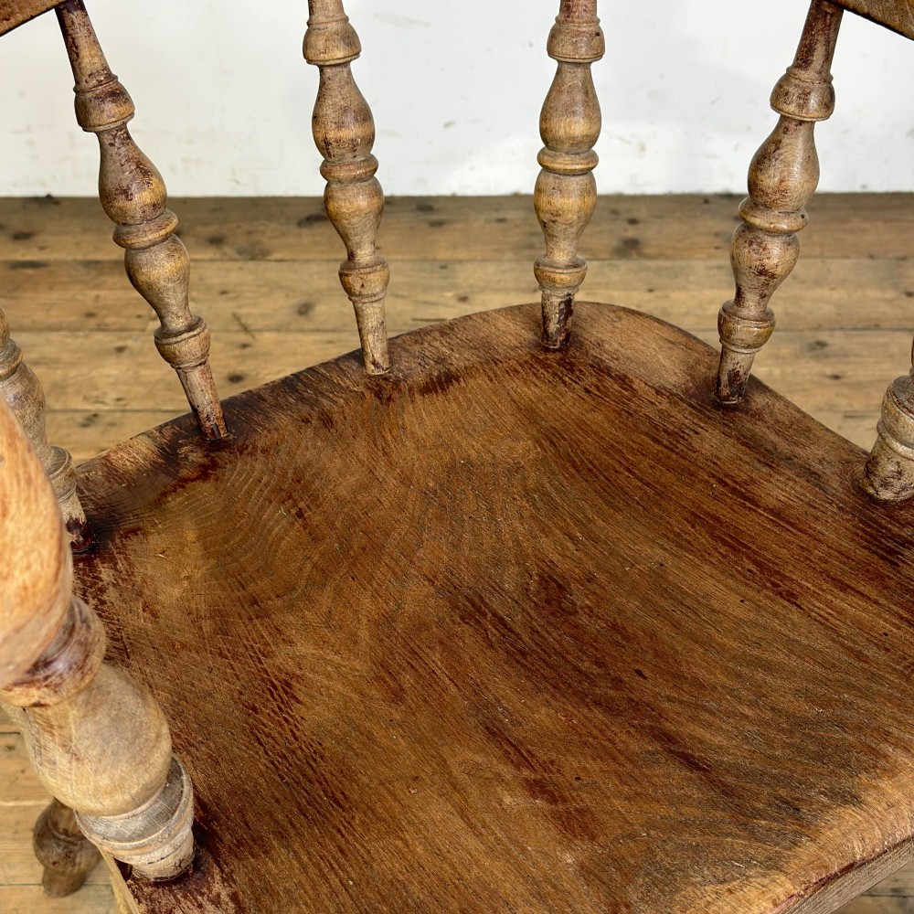 An antique wooden smokers bow armchair with turned spindles, a curved horseshoe armrest, and turned legs. View VIII