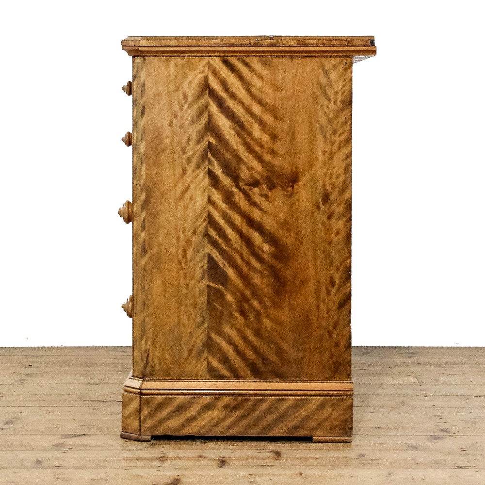 A Victorian satinwood chest of drawers with turned wooden handles, subtle geometric inlaid banding, and a broad plinth base. View IV