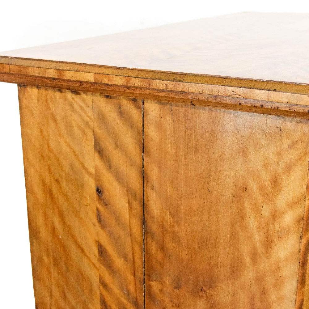 A Victorian satinwood chest of drawers with turned wooden handles, subtle geometric inlaid banding, and a broad plinth base. View VII