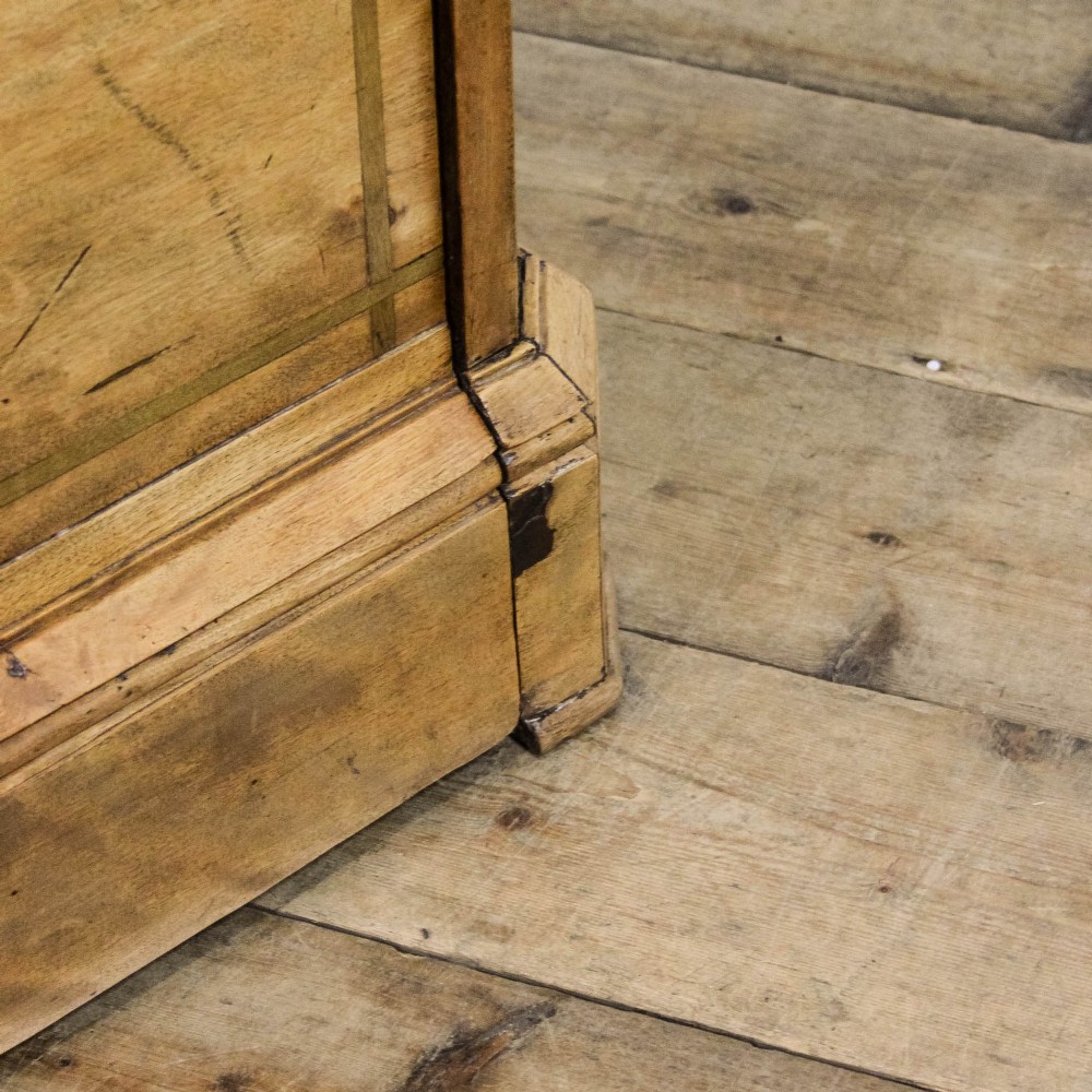 A Victorian satinwood chest of drawers with turned wooden handles, subtle geometric inlaid banding, and a broad plinth base. View X