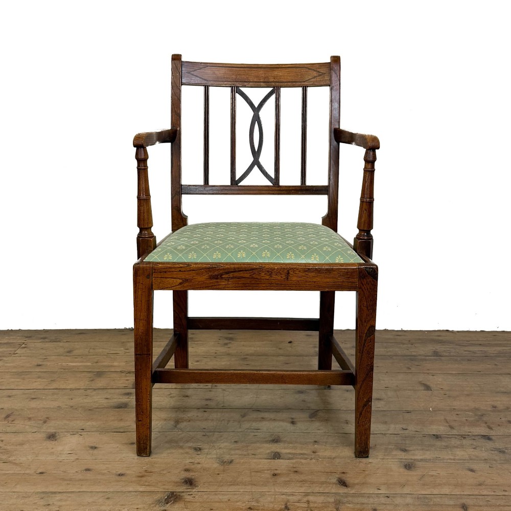 A set of six antique oak dining chairs, including two carvers, featuring geometric inlaid crest rails, decorative back splats, and light green patterned fabric seats. View III