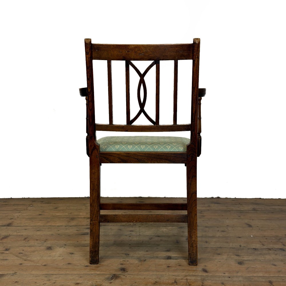 A set of six antique oak dining chairs, including two carvers, featuring geometric inlaid crest rails, decorative back splats, and light green patterned fabric seats. View VI